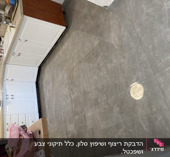 מטבח עם ארונות לבנים ורצפת שיש אפורה